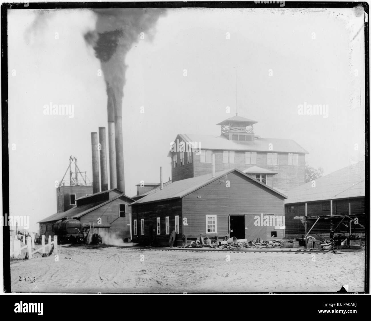 . Anglais : Extérieur de l'usine de sucre de betterave du Pacifique à San Francisco, comté de Tulare, ca.1906 Photo de l'extérieur de l'usine de sucre de betterave du Pacifique à San Francisco, comté de Tulare, ca.1906. Deux des quatre cheminées belch fument dans l'air sur l'un des 4 bâtiments visibles. Un wagon (numérotées de 95579) est situé sur un embranchement de chemin de fer qui longe la route de terre en face de l'usine. Un homme et un cheval sont visibles à proximité. La plupart des bâtiments visibles sont 1 étages à l'exception de 2 ou 3 étages bâtiment plus grand derrière les autres. Un signe sur le bâtiment au premier plan est la suivante : "la colère [...]". Numéro d'appel : Banque D'Images