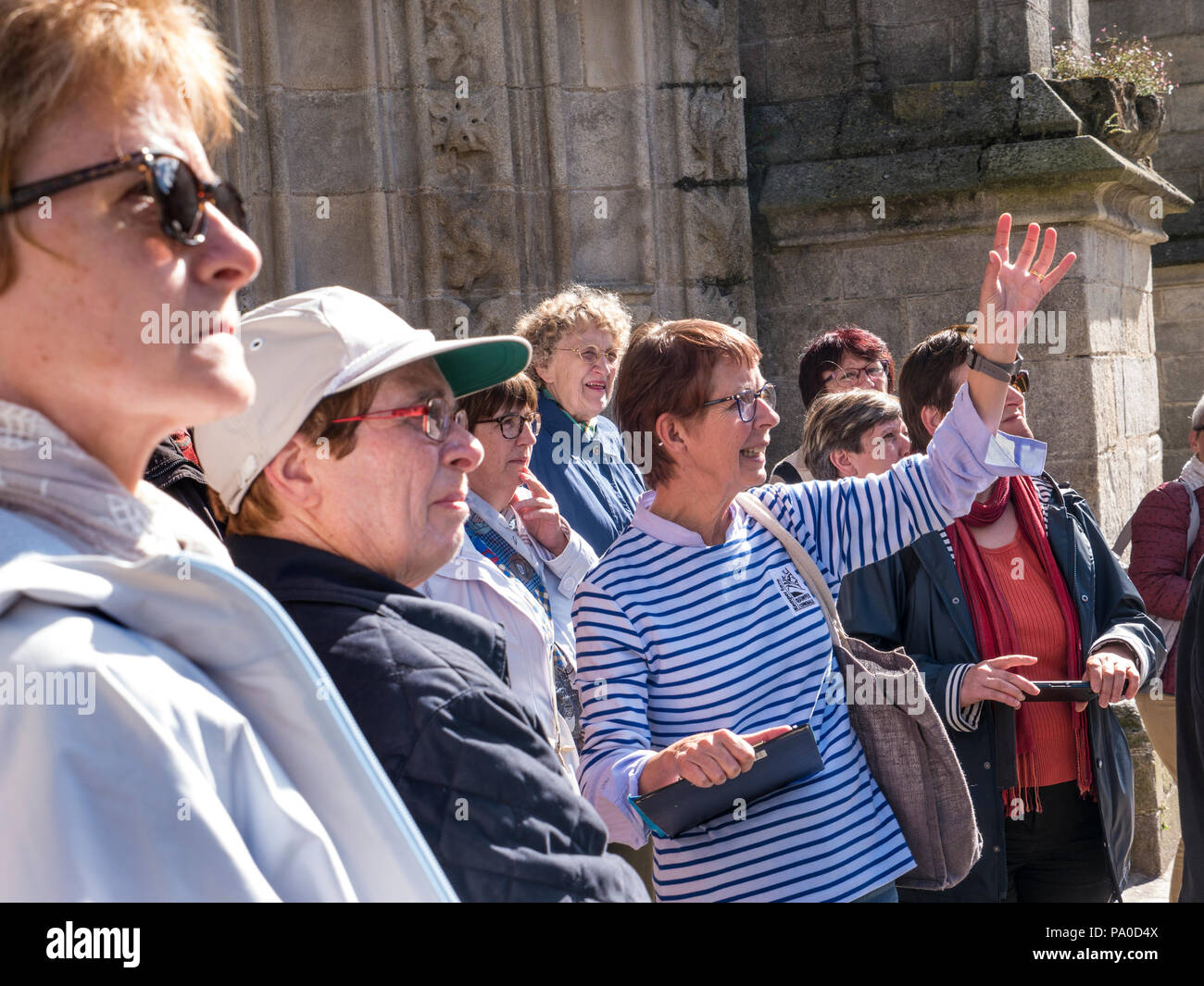 Guide touristique avec son groupe de tournée entièrement féminin dans le plein débit à l'extérieur de la cathédrale de Quimper, convenablement la cathédrale Saint Corentin de Quimper Bretagne France Banque D'Images