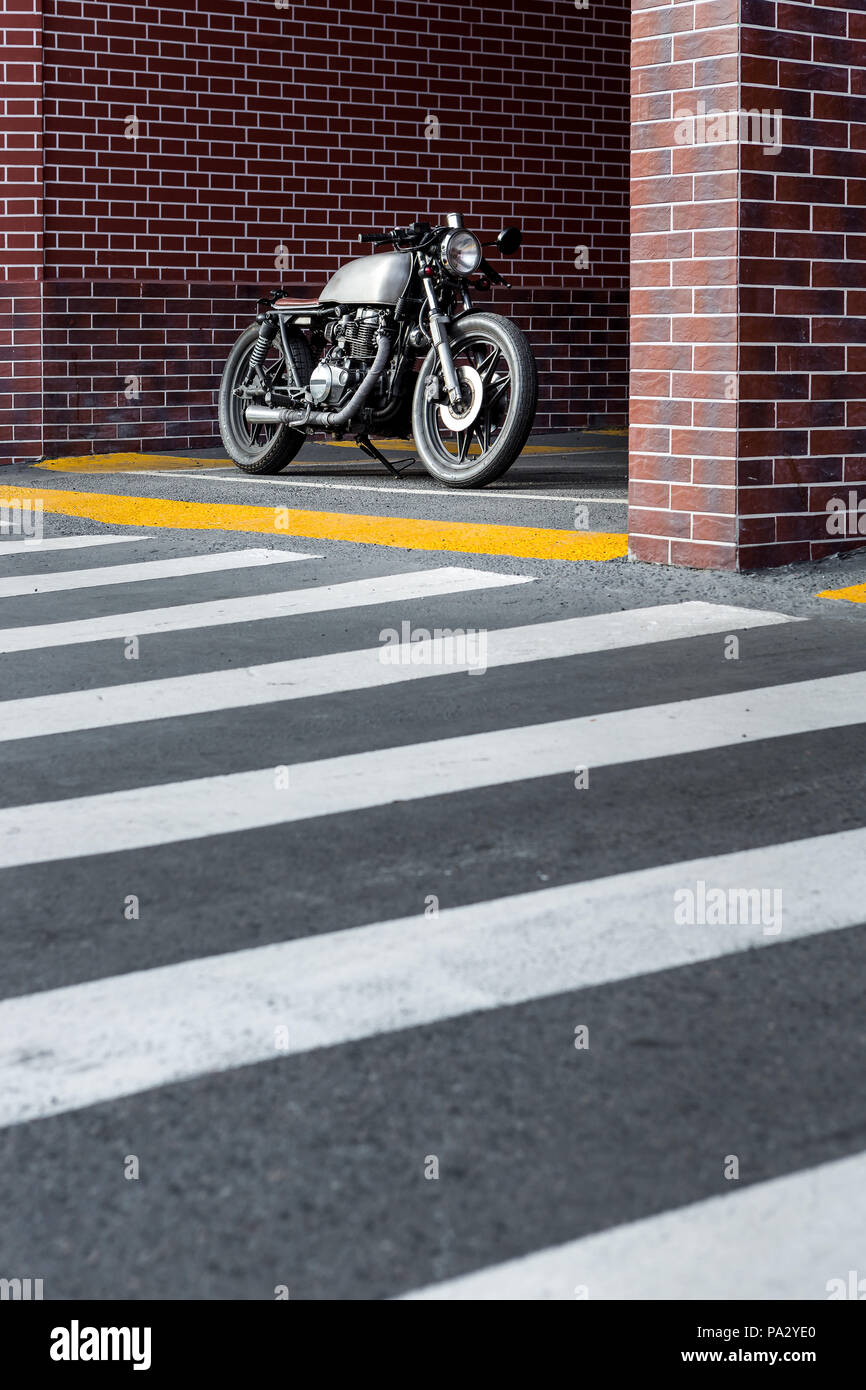 Les moto parking près de mur de briques de bâtiment industriel. Tout est prêt pour s'amuser après une dure journée au bureau. Man City hanches Banque D'Images