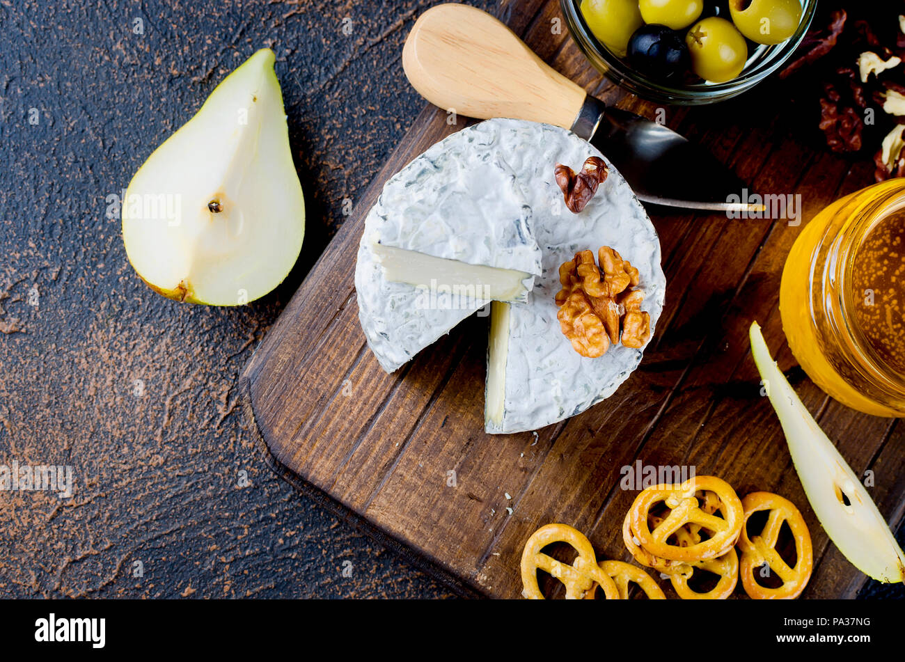 Tranches de fromage, fromage par la rouille, fromage à pâte dure, les olives, les noix, les arachides, le miel, un verre de vin, un dîner romantique, un repas pour les shurman Banque D'Images