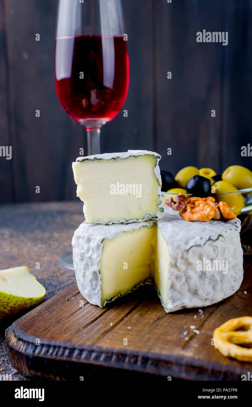 Tranches de fromage, fromage par la rouille, fromage à pâte dure, les olives, les noix, les arachides, le miel, un verre de vin, un dîner romantique, un repas pour les shurman Banque D'Images