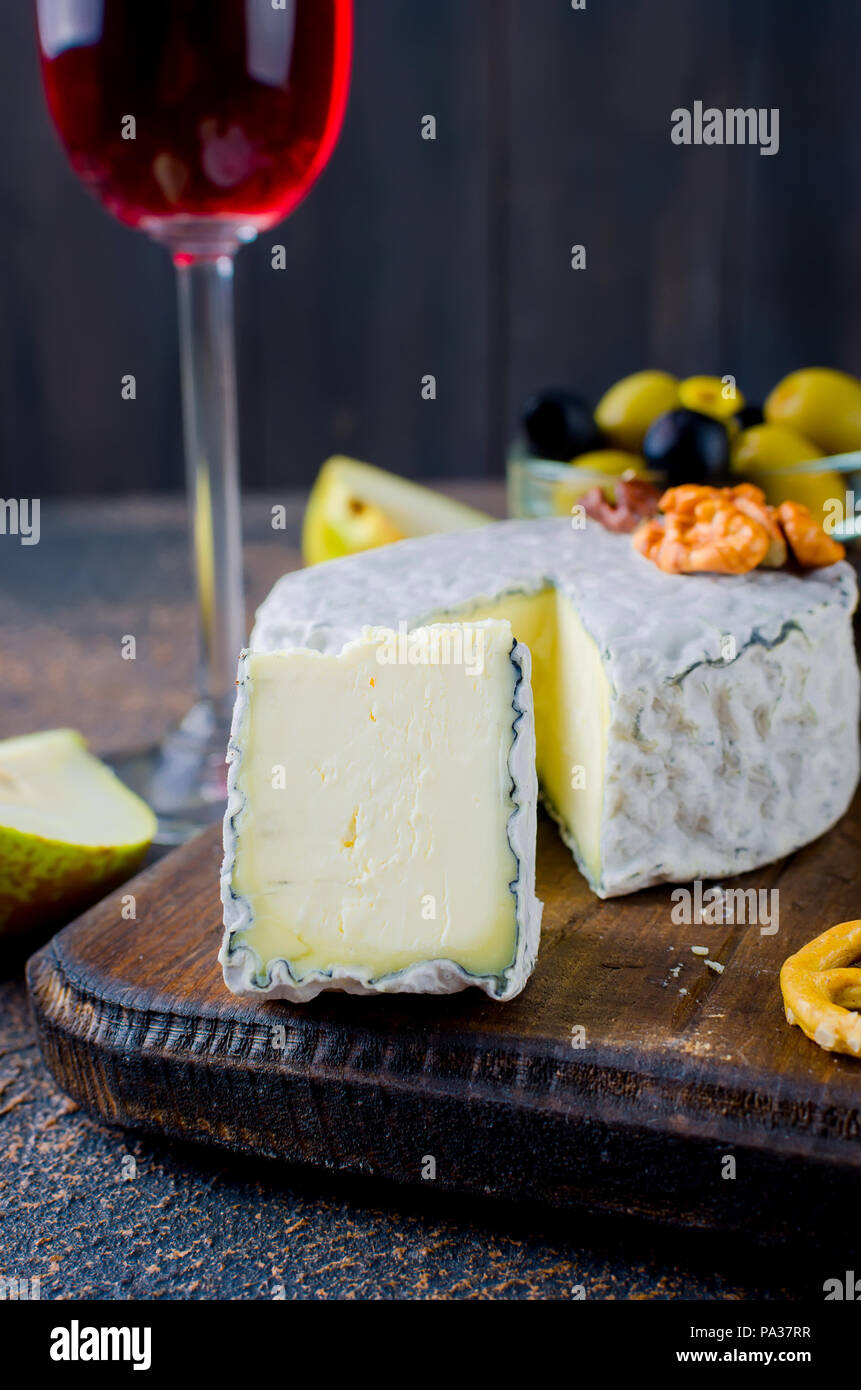 Tranches de fromage, fromage par la rouille, fromage à pâte dure, les olives, les noix, les arachides, le miel, un verre de vin, un dîner romantique, un repas pour les shurman Banque D'Images