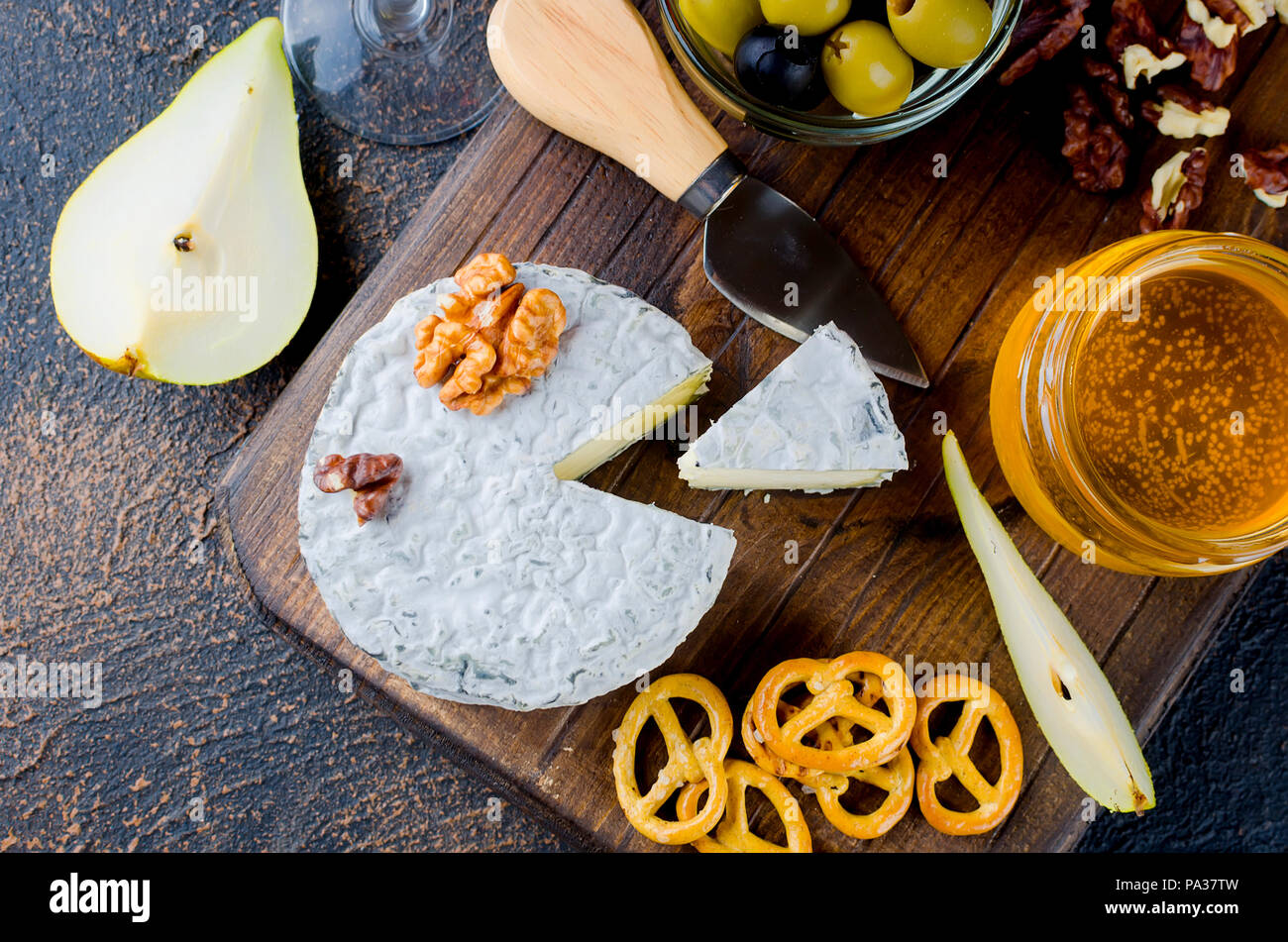 Tranches de fromage, fromage par la rouille, fromage à pâte dure, les olives, les noix, les arachides, le miel, un verre de vin, un dîner romantique, un repas pour les shurman Banque D'Images