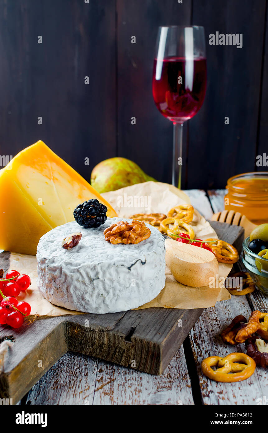 Tranches de fromage, fromage par la rouille, fromage à pâte dure, les olives, les noix, les arachides, le miel, un verre de vin, un dîner romantique, un repas pour les shurman Banque D'Images