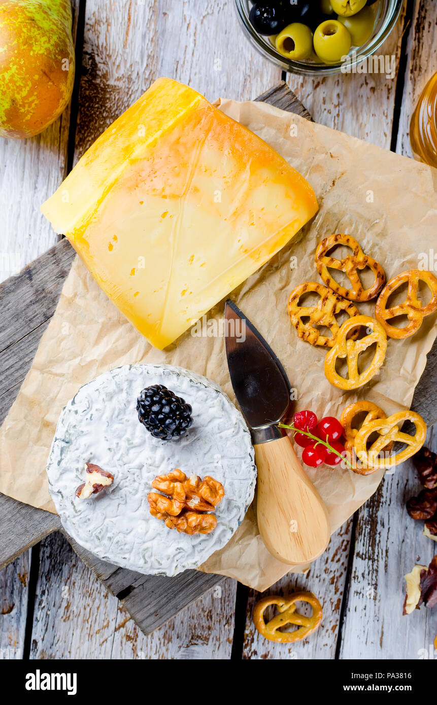 Tête de caillé de fromage bleu et olives. Le miel et poire, pomme sur la vieille table en bois blanc, vue du dessus Banque D'Images