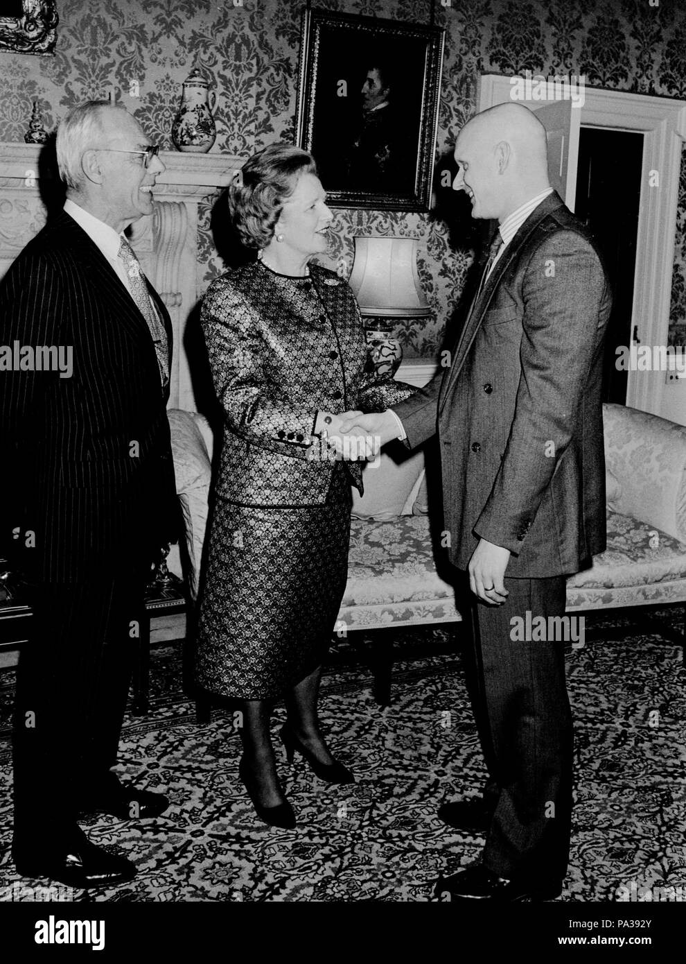 Le premier ministre Margaret Thatcher, regardée par son mari Denis, médaillé d'or olympique accueille Duncan Goodhew au 10 Downing Street, Londres, au cours d'une réception organisée pour les membres de l'équipe des Jeux Olympiques d'hiver britannique et des célébrités du show business. Banque D'Images