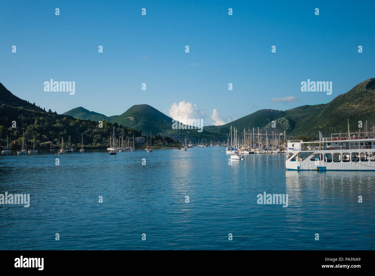 Paysage bleu de la côte de mer avec des bateaux et des montagnes vertes en arrière-plan Banque D'Images