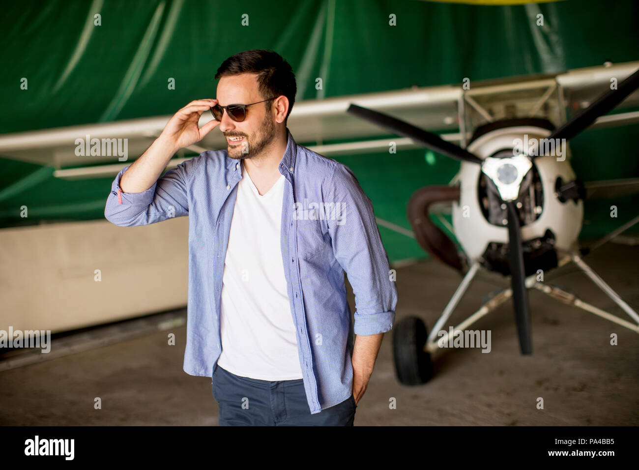 Beau jeune homme dans le hangar avion Banque D'Images