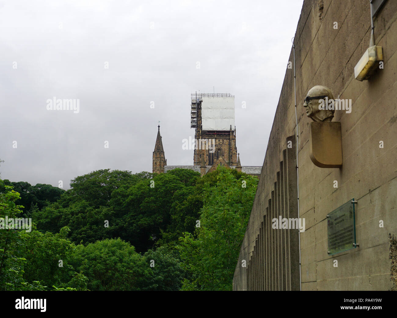 Contraste entre l'ancienne et moderne à l'architecture brutaliste montrant la cathédrale de Durham et Dunelm maison avec la statue de Ove Arup sur le mur Banque D'Images