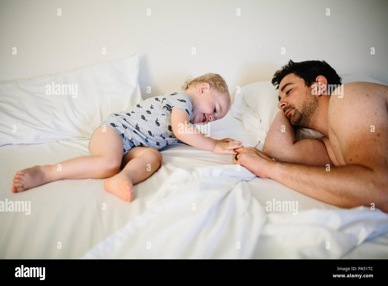 Le père et l'enfant dans le lit jouant Banque D'Images
