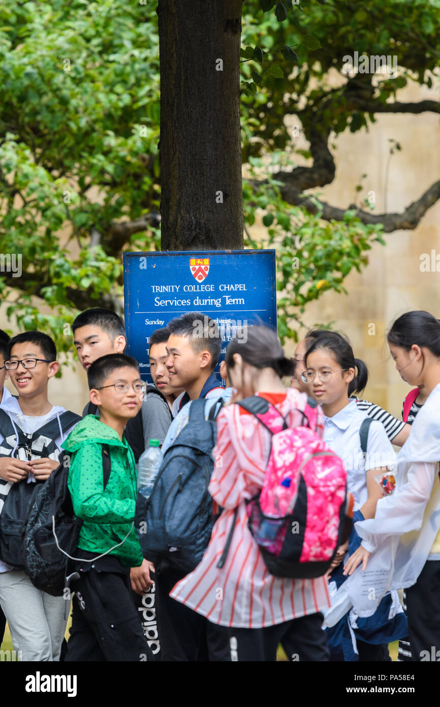 Un groupe d'écoliers chinois visiter Cambridge, Angleterre, se tenir à l'extérieur de l'université Trinity College. Banque D'Images
