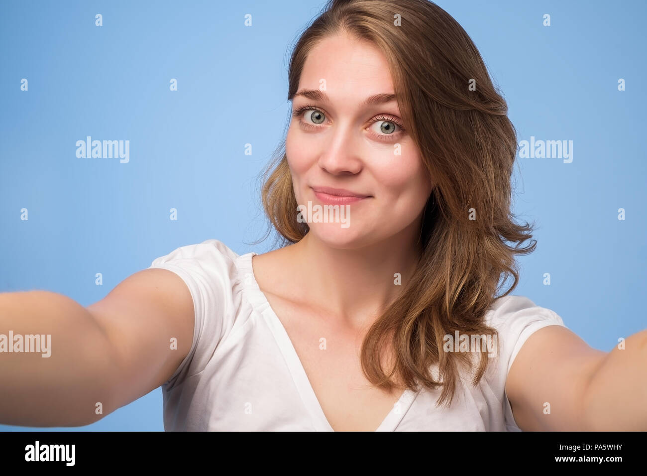 Close-up of young european belle femme prendre. selfies Isolé sur fond bleu Banque D'Images