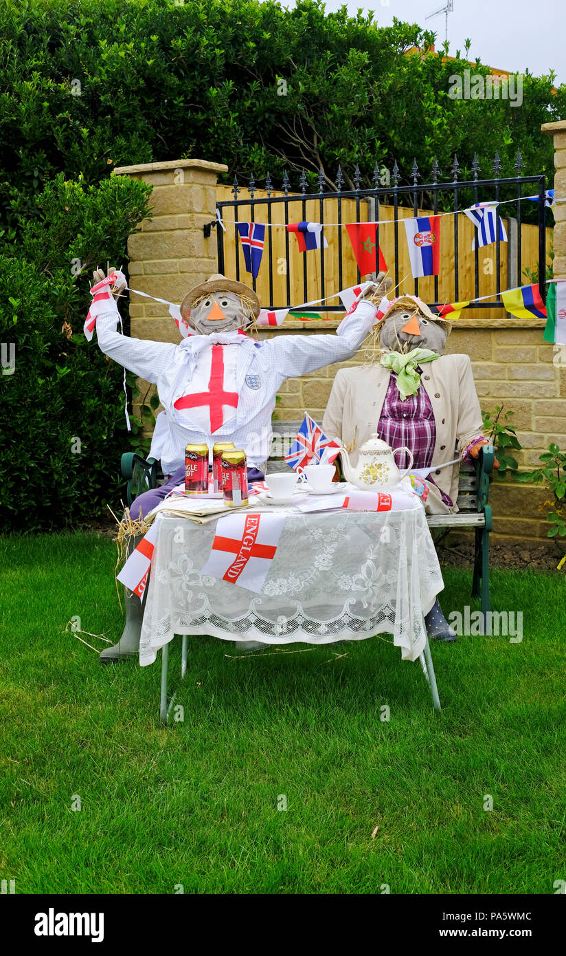 Paire d'épouvantails habillés en Angleterre les supporters de football ayant le thé l'après-midi. Banque D'Images