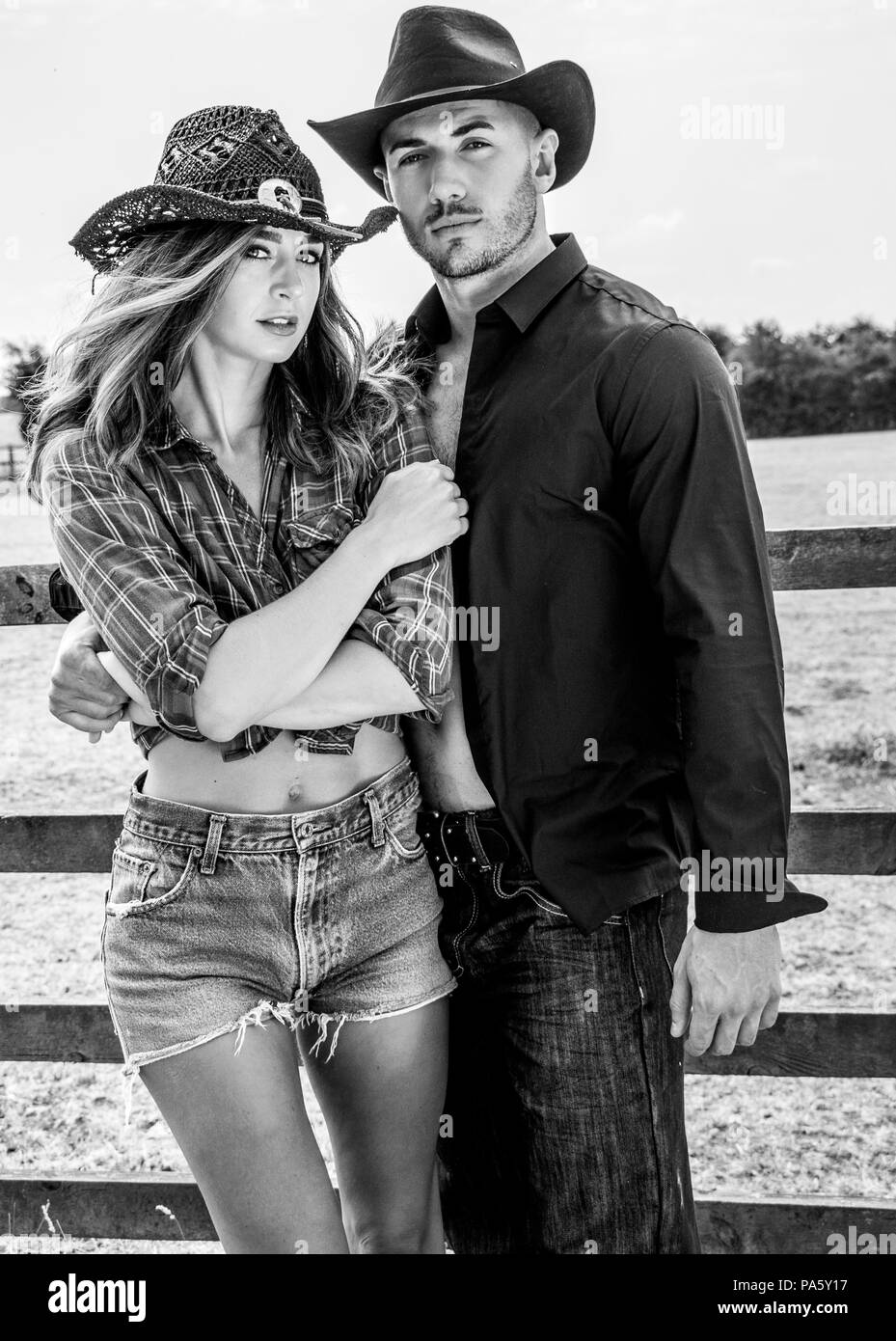 Caractères de country et western cowboy et cowgirl lutte à côté d'une clôture en bois et les champs Banque D'Images