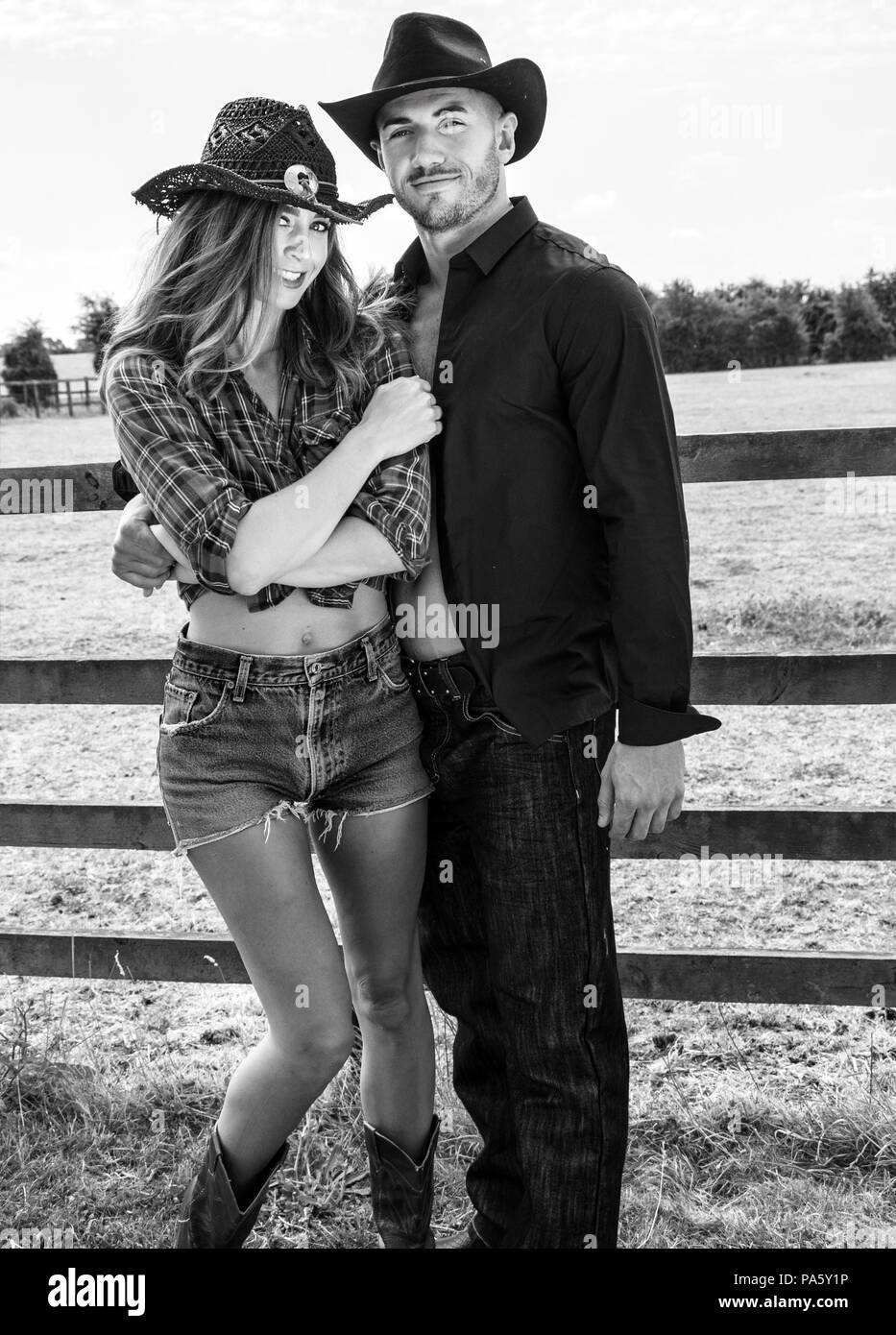 Caractères de country et western cowboy et cowgirl lutte à côté d'une clôture en bois et les champs Banque D'Images