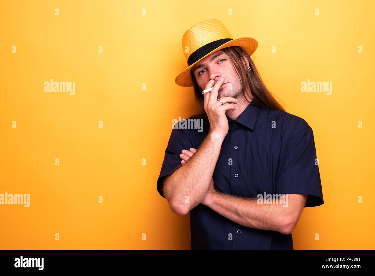 Cigarette mâles adultes et wearing hat Banque D'Images