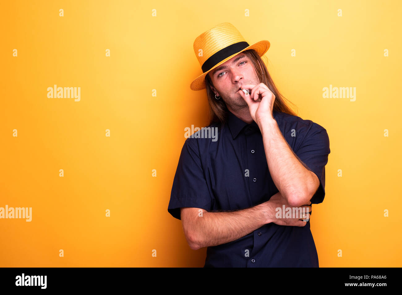 Cigarette mâles adultes et wearing hat Banque D'Images