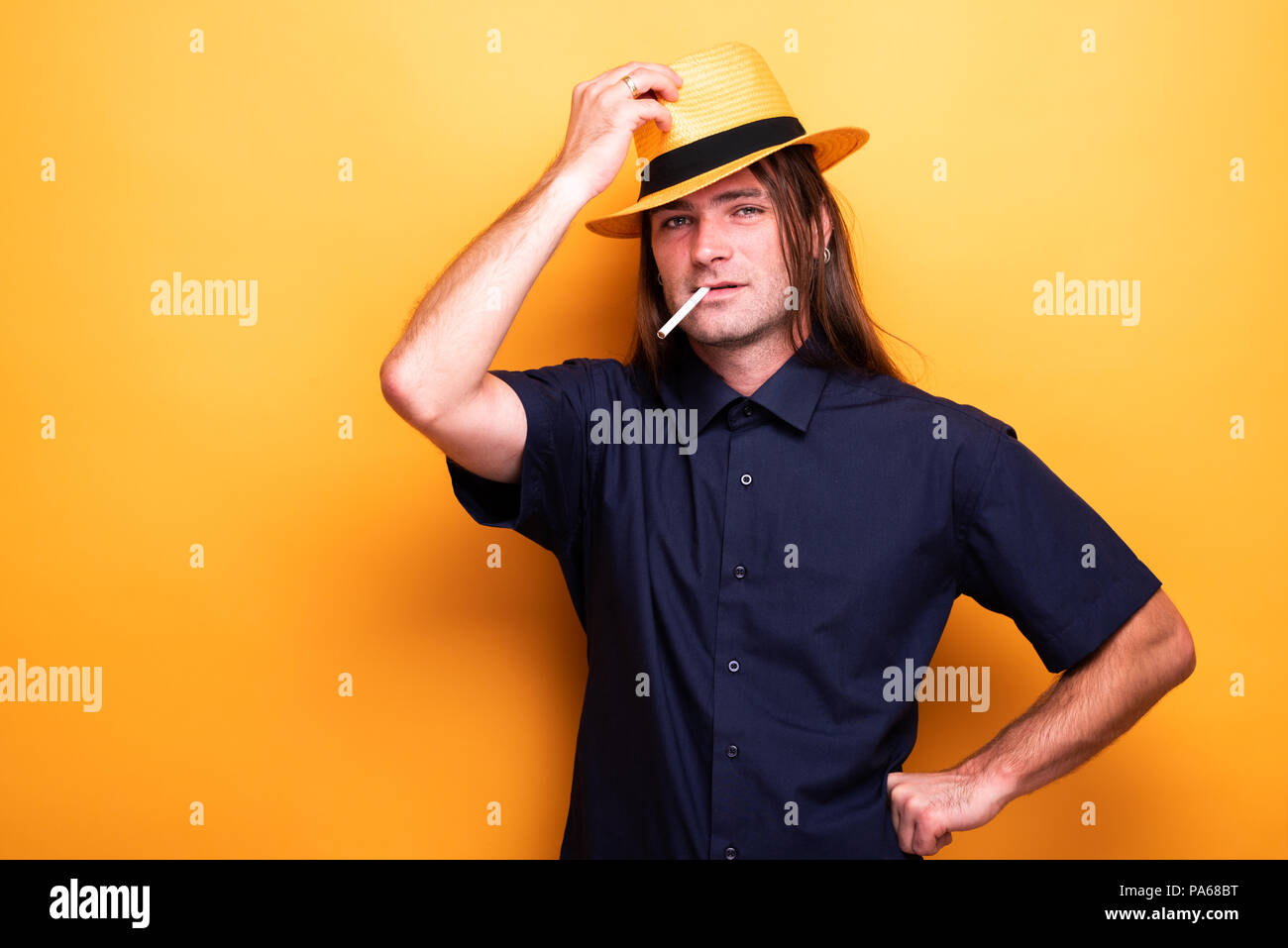 Cigarette mâles adultes et wearing hat Banque D'Images