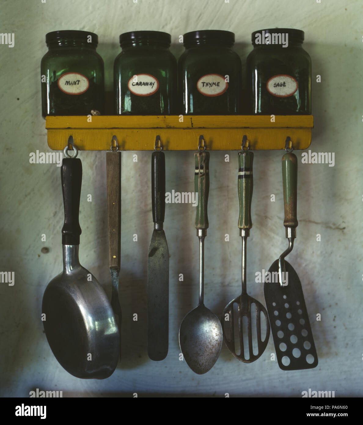147 ustensiles de cuisine accroché au-dessous d'un rack d'épices Banque D'Images