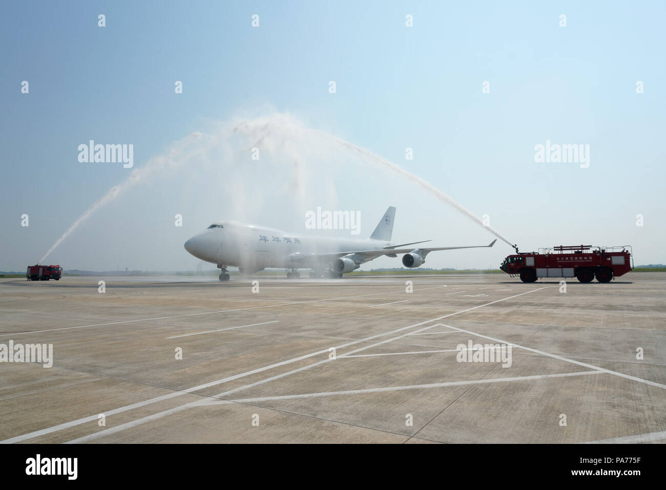 Changsha, Chine, province du Hunan. 21 juillet, 2018. Véhicules de lutte contre l'incendie pulvériser de l'eau pour accueillir un avion cargo à l'aéroport international Huanghua de Changsha, capitale de la province du Hunan en Chine centrale, le 21 juillet 2018. Le Changsha-North America continental cargo réguliers compagnie aérienne, la première du genre dans la province du Hunan, a fait un voyage réussi le samedi. Les trois avions de fret des vols entre Changsha et en Amérique du Nord sont attendus chaque semaine pour raccourcir le temps de transport et des frais de fonctionnement. Credit : Zhang Xiaoyu/Xinhua/Alamy Live News Banque D'Images