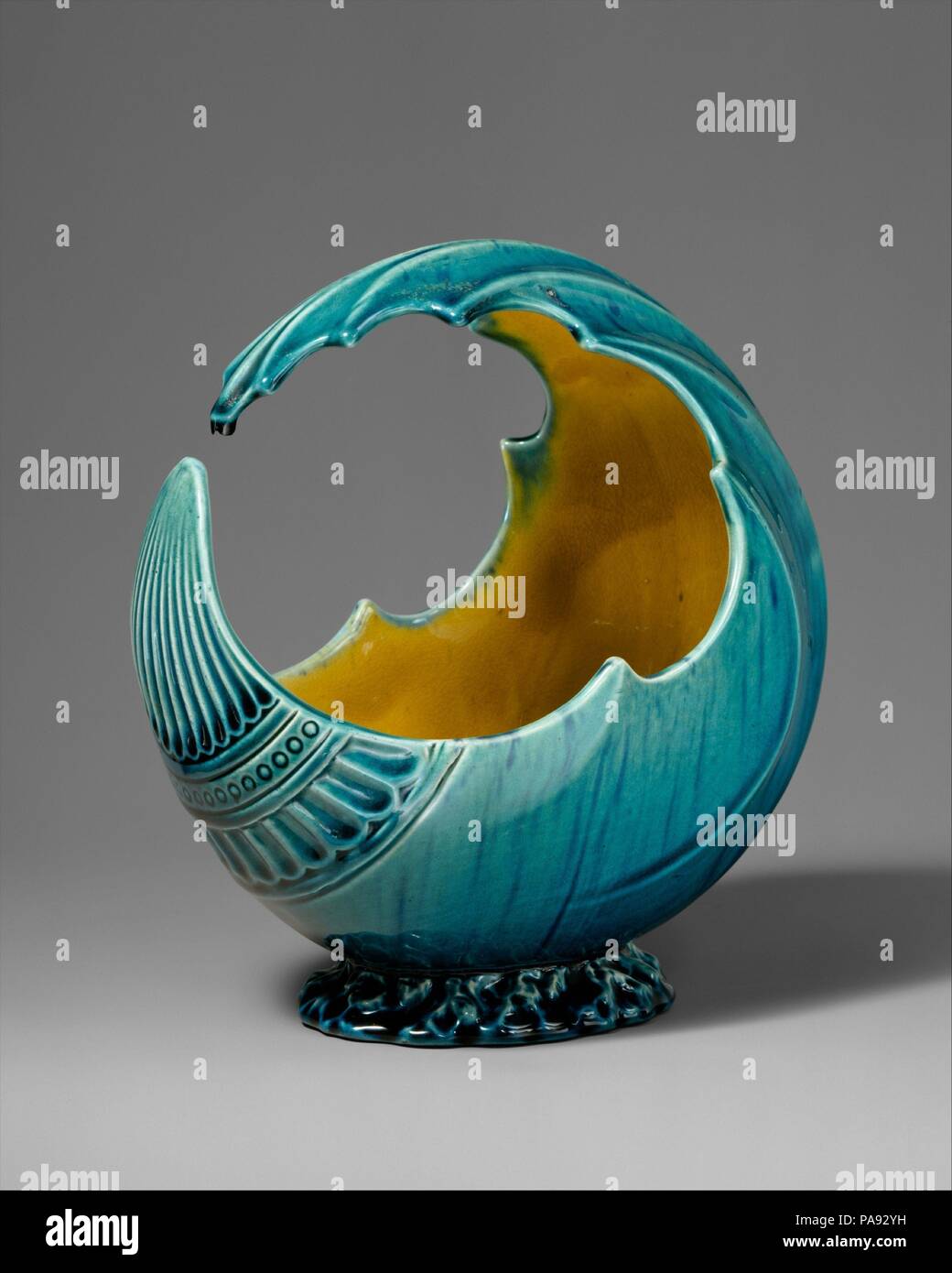 Bol de l'onde. Culture : British, Linthorpe, Yorkshire. Designer : attribuée à Christopher Dresser (britannique, Glasgow, Écosse 1834-1904 Mulhouse). Dimensions : hors tout : 7 × 7 × 4 1/2 in. (17,8 × 17,8 × 11,4 cm). Fabricant : Linthorpe Pottery Works (britannique, 1879-1889). Date : ca. 1880. Ce bol, couverts d'une glaçure vert-turquoise avec un intérieur rayé jaune et vert, est moulé pour suggérer une vague cresting. Plus de moulée avec gadrooning et une bande de petits cercles, le bol reflète diverses sources sur lesquelles Christopher Dresser s'appuyait. Les estampes japonaises fortement influencé décoratif européen Banque D'Images