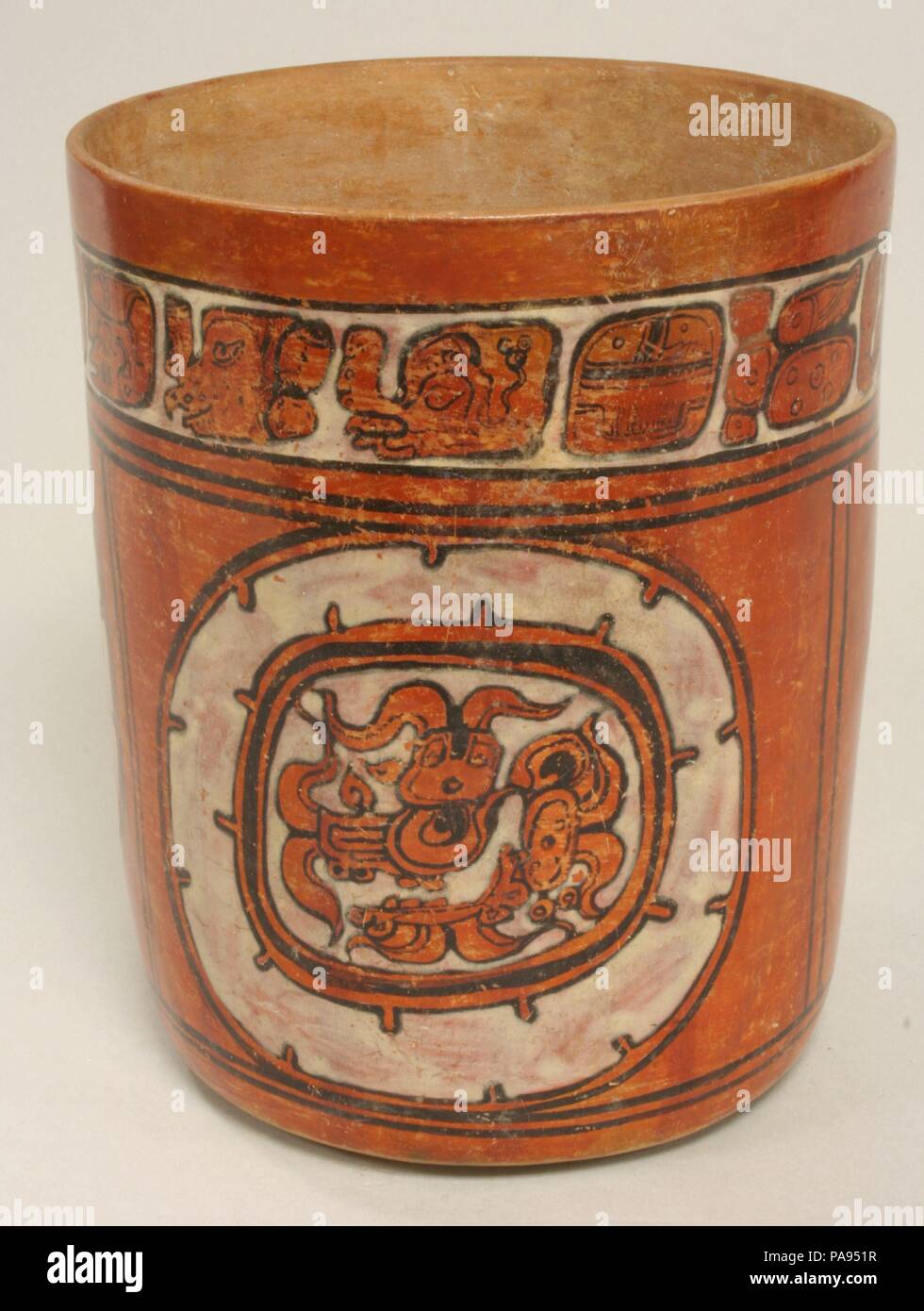 Cuve cylindrique. Culture : Maya. Dimensions : H. 7 7/8 x diam. 6 1/4 in. (18,1 x 15,9 cm). Date : 6ème-9ème siècle. Ce vaisseau cylindrique polychrome est identifié par le texte autour du bord comme un classique maya (vers l'an 250-900) vans tractés cup.' la disposition de conception est moins commune que la pleine figure des scènes et représentations de la déité vu sur de nombreux navires Maya. L'interprétation de la déité profil bien dessiné la tête est qu'il est peut-être l'une des nombreuses formes d'un serpent aqueux créature, une image commune dans l'art Maya, souvent avec des nuages de fumée provenant de la partie supérieure, inférieure, gauche et droite de la tête. Le split Banque D'Images