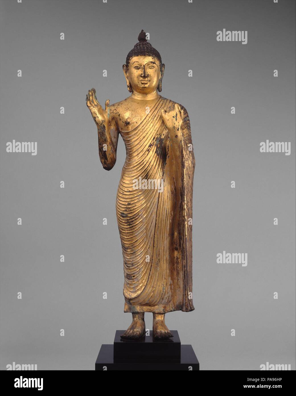 Offrant la protection de Bouddha. Culture : Sri Lanka, du plateau central. Dimensions : H. (figure) 23 3/4 in. (60,3 cm) ; W. 7 in. (17,8 cm) ; D. 4. (10,2 cm). Date : 10e siècle. Ce grand Bouddha de compassion aux fidèles des gestes de protection (Abhaya mudra) avec sa main droite posée, tandis que sa main gauche prend en charge la grande chute de sa robe monastique (uttarsanga). Les traits du visage et contour corporel suggèrent que le travail est un produit de la première période de Polonnaruva. Musée : Metropolitan Museum of Art, New York, USA. Banque D'Images