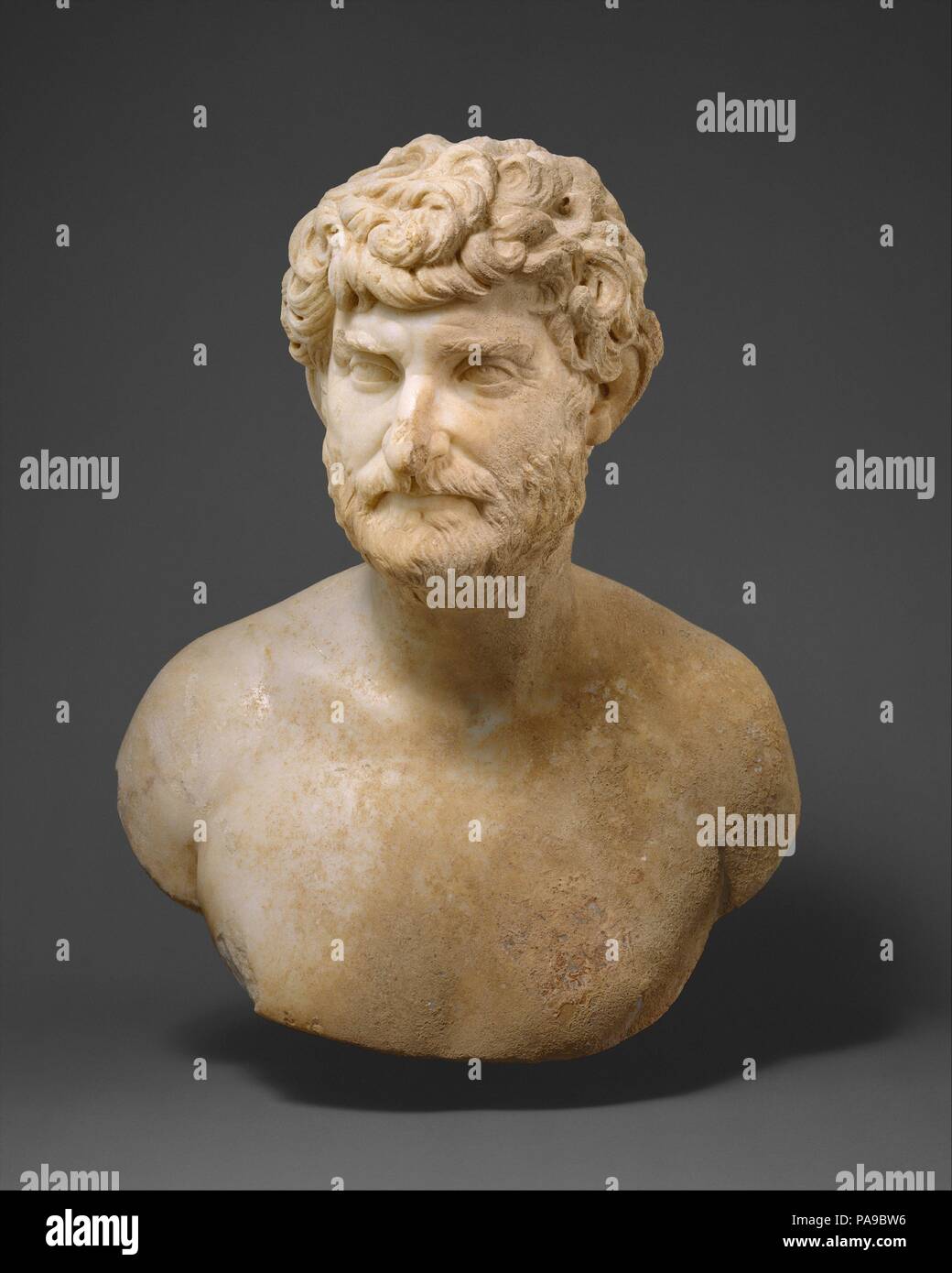 Buste en marbre d'un homme barbu. Culture : Roman. Dimensions : H. 22 in. (55,9 cm). Date : ca. A.D. 150-175. Ce buste d'un homme d'âge moyen vigoureux avec tête tourné brusquement et regard perçant est un magnifique exemple de l'art du portrait psychologique et donne une impression de concentration intense. Comme de nombreux portraits de la mi-deuxième siècle après J.-C., ce travail partage de nombreuses caractéristiques avec le type de portrait utilisé pour représenter l'ensemble des philosophes de l'antiquité. Il est peu probable, cependant, que l'Homme montré ici a suivi cette profession. Le buste a été conçu pour être considérée strictement par l'avant. Le haut et Banque D'Images