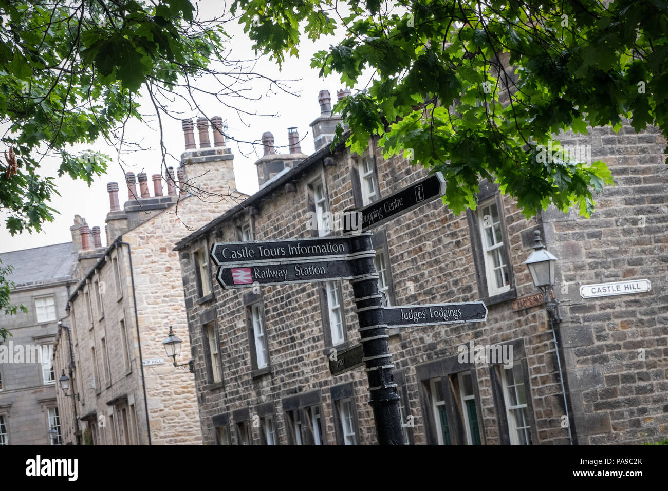 À la recherche jusqu'à un panneau de rue près du château dans le centre-ville de Lancaster avec les arbres, les bâtiments de la ville, des cheminées et du ciel Banque D'Images