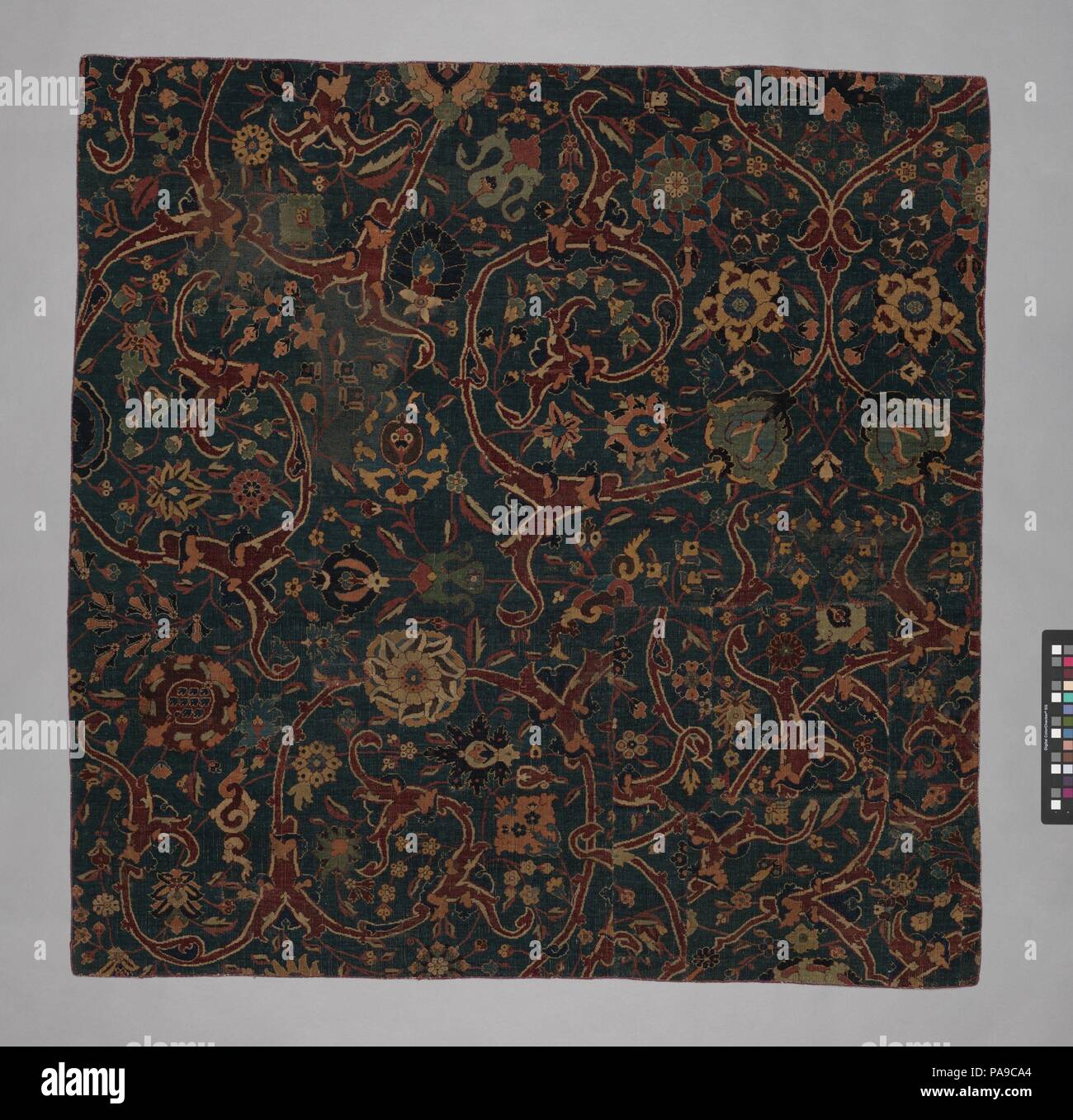 Rez-de-bleu avec fragment de tapis Floral Défilement des vignes. Dimensions : Rug : H. 54 1/8 in. (137,5 cm) W. 53 5/8 po. (136,2 cm). Date : le 17e siècle. Ce fragment d'un tapis porte une variété de fleurs sur tiges sinueuses sur un fond bleu. Sa structure, qui est composé de deux plans de fils de chaîne, indique qu'elle a probablement produit dans la ville de Kirman, dans le sud-est de l'Iran. Les tapis de cette ville d'afficher un large éventail de modèles mais se ressemblent dans la construction. Exportés en Inde pendant le règne de l'empereur Akbar (r. 1556-1605), Kirman tapis étaient connus pour être parmi les meilleurs produits Banque D'Images