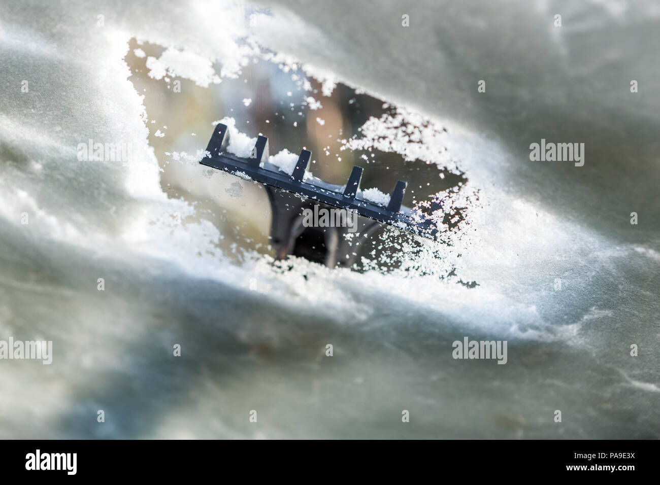 Nettoyage de fenêtre de voiture de la neige et de la glace. Le grattage de la glace sur un pare-brise a été prise par l'intérieur de la voiture. Transports - winte Banque D'Images