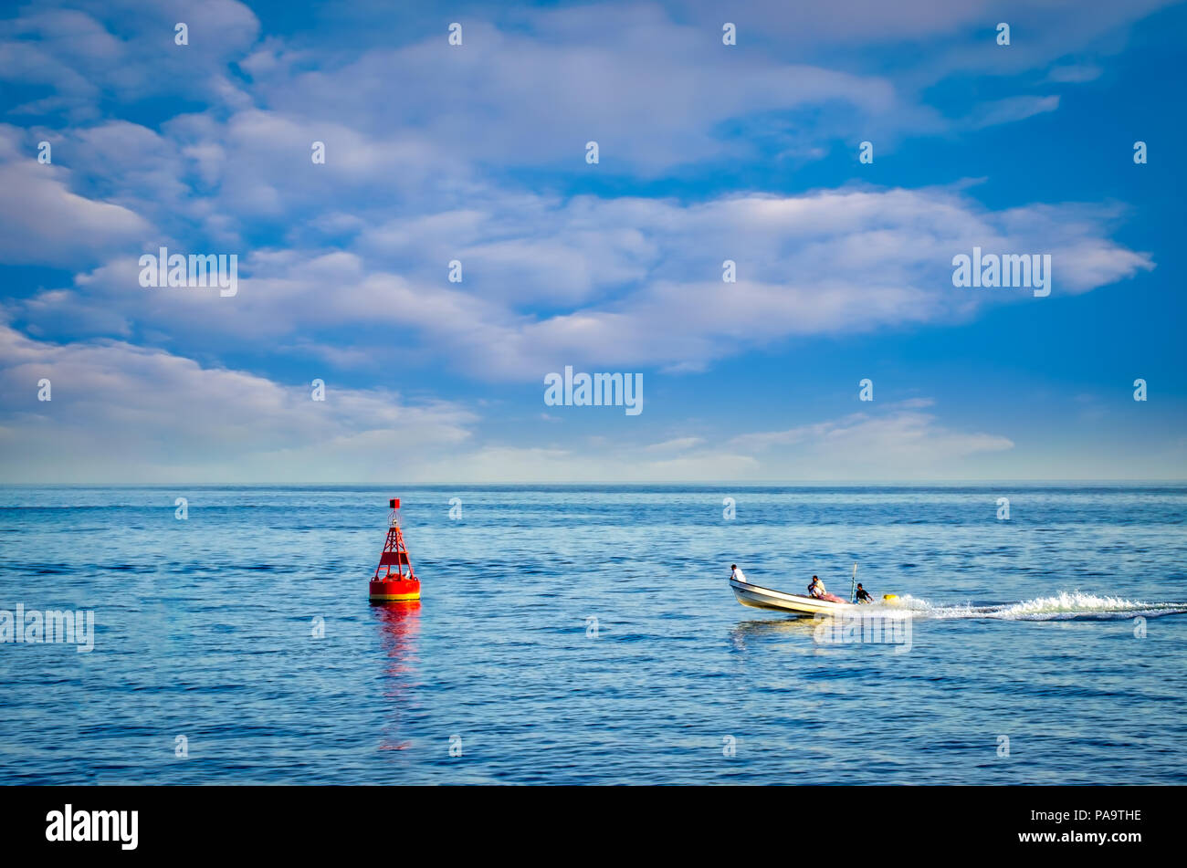 Une pêche rapide bateau à une bouée sous un ciel bleu. Banque D'Images