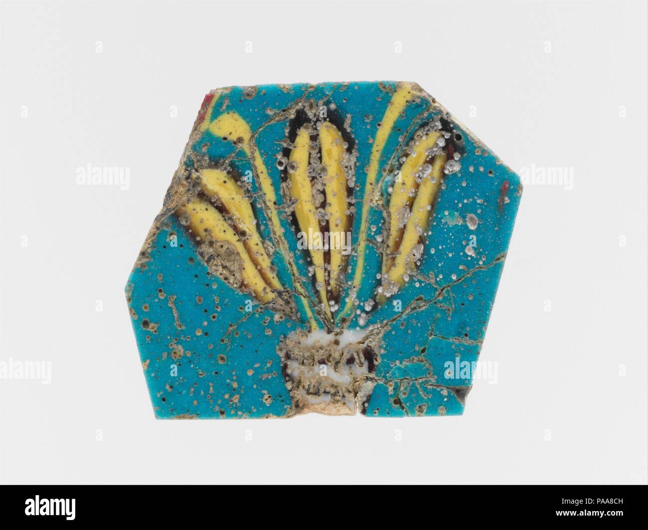 Incrustation en mosaïque de verre. Culture : l'Egyptien, Roman. Dimensions : d'autres : 1 1/2 in. (3,8 cm). Date : premier siècle avant J.-C. au 1er siècle de notre ère. Semi-opaque bleu turquoise motif ; décoration en opaque, blanc et jaune, et mauve-foncé translucide figurant noir, opaque et bleu de cobalt rouge apparaissant sur la face inférieure. Polygonale, plaque plate avec légèrement biseautées. Motif floral jaune avec les feuilles et les bourgeons, décrites en violet, l'émission à partir d'une base en violet et blanc rayures horizontales. Cassé et réparé avec de grandes fissures et petites pertes ; face supérieure et polie ; surface piquée de bulles. Musée : M Banque D'Images