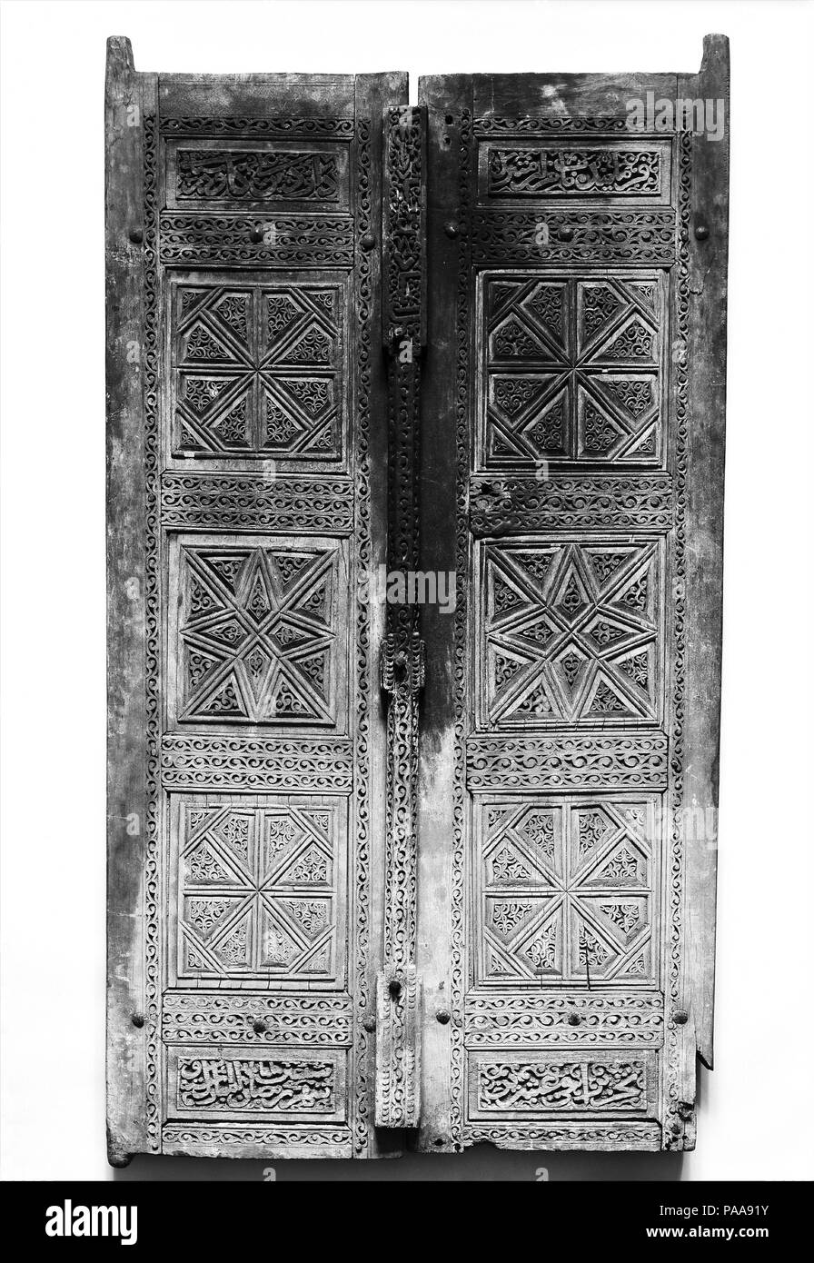 Paire de portes sculptées. Dimensions : H. 59 1/4 in. (150,5 cm) W. 32 in. (81,3 cm) Gr. D. 3 1/2 in. (8,9 cm) WT. 48 lbs (21,8 kg). Date : du 1466. Ces portes en teck se composent de plusieurs panneaux épigraphiques décoratifs et réunis et insérés dans un cadre. La paire de panneaux avec des dessins géométriques sculptés boiseries iranien reflète du xve siècle. Un cénotaphe, datée du 1473, aujourd'hui au Musée de l'Art, Rhode Island School of Design, affiche très semblables dessins et inscriptions. Le défilement des panneaux ossature vignes et sur la barre verticale partager qualités avec motifs vagues vu en Ti Banque D'Images
