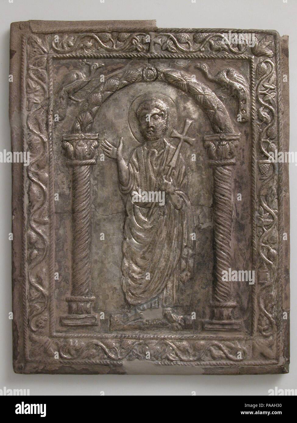 Plaque avec Saint Pierre. Culture : Byzantine. Dimensions : hors tout : 10 13/16 x 8 1/2 x 1/2 in. (27,4 x 21,6 x 1,3 cm) (l'ensemble de fixation avec 50.5.1) : 15 x 22 x 7/8 in. (38,1 x 55,9 x 2,2 cm). Date : 550-600. L'image typique de Saint Pierre--avec un visage rond, cheveux courts, et une barbe--a été établi pendant les premiers siècles de l'église chrétienne. Ici Peter se tenant une croix et gesticulant comme si la prédication. À la taille sont les clés du royaume des cieux, qui lui avaient été donnés par le Christ (Matthieu 16:19). L'arche flanquée de paons dans lesquelles Peter s'est considéré comme une représentation de parad Banque D'Images