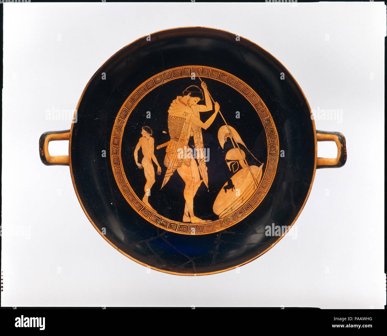 Terre cuite kylix (coupe potable). Culture : le grec, le grenier. Dimensions : H. 5 3/16 in. (13,2 cm) ; diamètre 13 1/8 in. (33,3 cm). Date : ca. 500 avant J.-C.. Intérieur, Extérieur, guerrier et garçon athlètes l'intérieur présente une amende mais aussi particulièrement sobre représentation d'un guerrier ; il saisit une lance et est accompagné d'un garçon, probablement d'un accompagnateur. L'artiste articulé avec soin les éléments de l'armure du guerrier et robe ; en mettant le casque d'un côté, il pourrait rendre le visage pensif, abattue. L'extérieur montre plus de scènes animées--boxe, lutte, et se prépare à lancer la diskos. Mu Banque D'Images