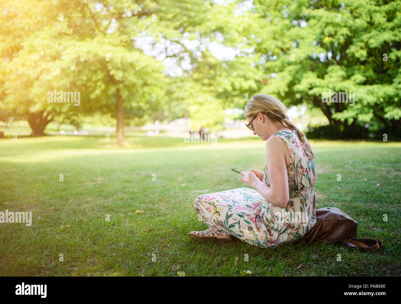 Woman using smartphone en parc public Banque D'Images