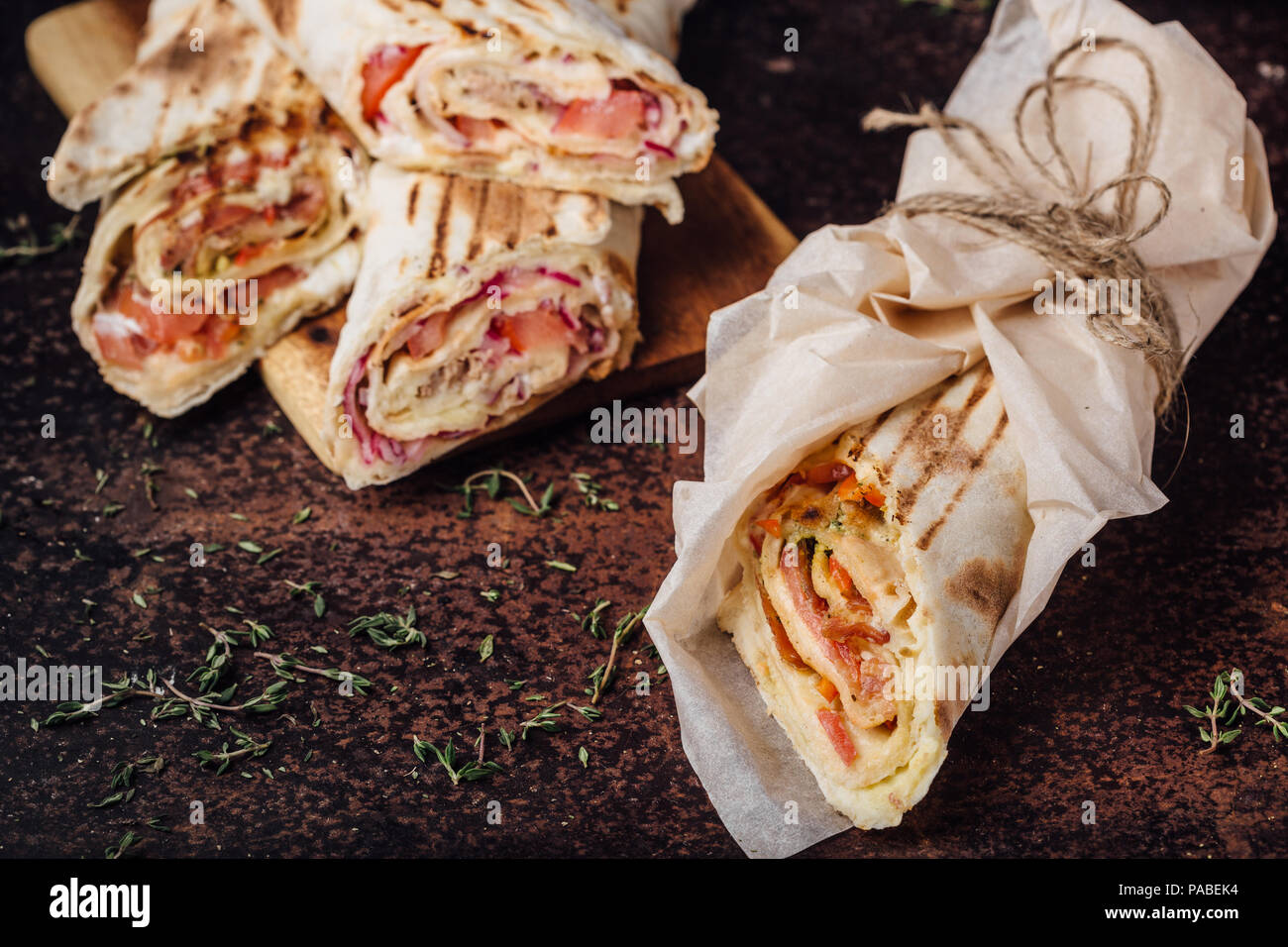 Sandwich Shawarma - un nouveau rouleau de lavash léger, rempli de viande grillée, champignons, fromage et fines herbes. Snack-oriental. Sur un fond de métal. Banque D'Images