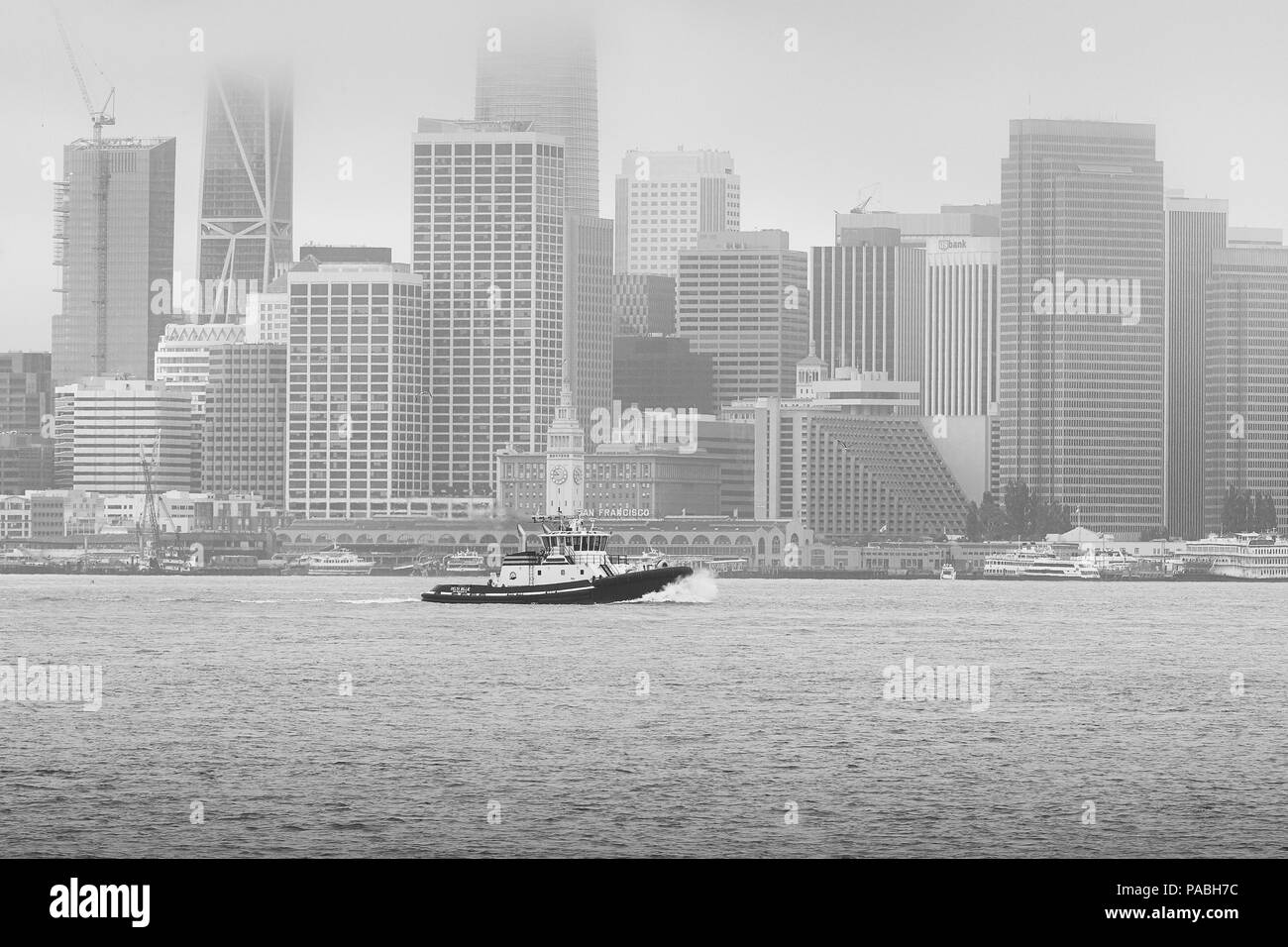 Photo en noir et blanc du Tugboat DELTA D'Oakland BLEU, en passant la Skyline de San Francisco. Banque D'Images