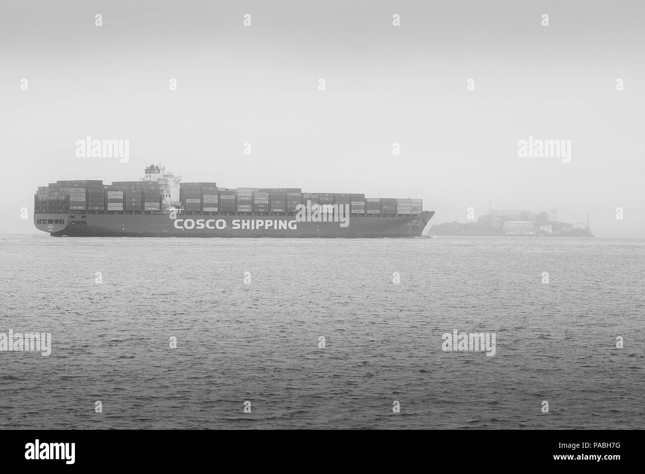Photo en noir et blanc du navire porte-conteneurs COSCO, CSCL BOHAI SEA approche d'Alcatraz alors qu'il quitte San Francisco dans la brume matinale Banque D'Images
