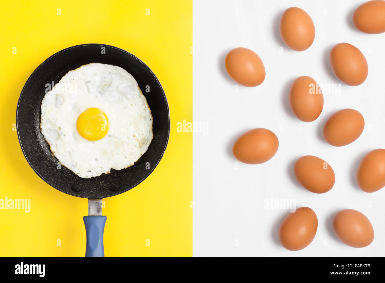 Oeufs frais et cuit dans une poêle avec des œufs crus placées aléatoirement sur fond blanc. À plat à l'image. Banque D'Images