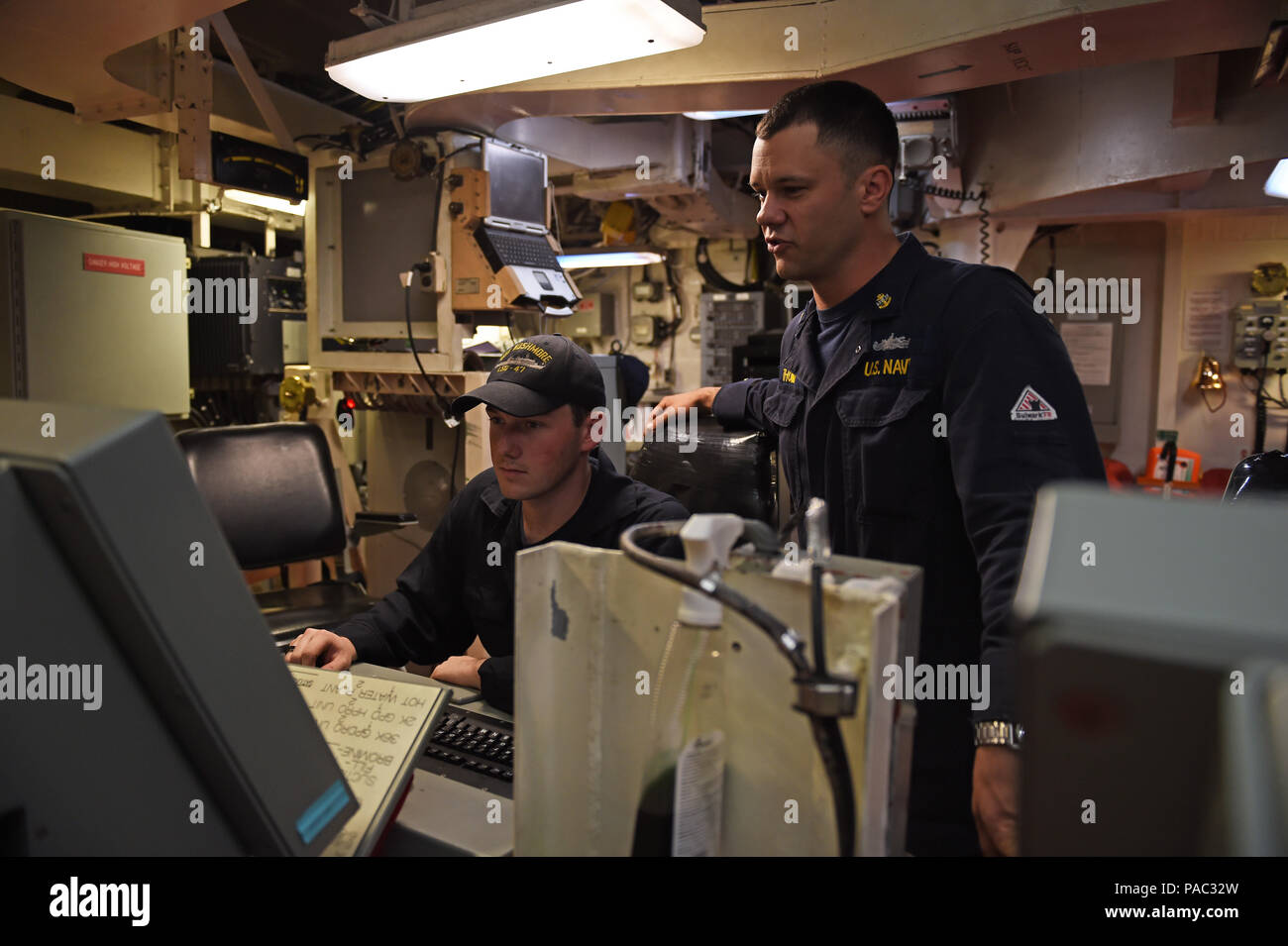 160306-N-9263B-024 SAN DIEGO (Mar. 6, 2016) - chef-électricien Jimmy Thomas (SW) trains Fireman (SW) Thomas sur la Chappell de la console de commande de propulsion et auxiliaires, qui a été mis à jour il y a quatre ans à bord du navire de débarquement quai amphibie USS Rushmore (LSD 47). Rushmore est prévu pour des mises à niveau au cours de l'état-major de la marine de l'opération de maintenance planifiée de la période de disponibilité (PMA) au chantier naval de BAE Systems à San Diego, le 6 mars. (U.S. Photo par marine Spécialiste de la communication de masse 2e classe Jason Baird/libérés) Banque D'Images