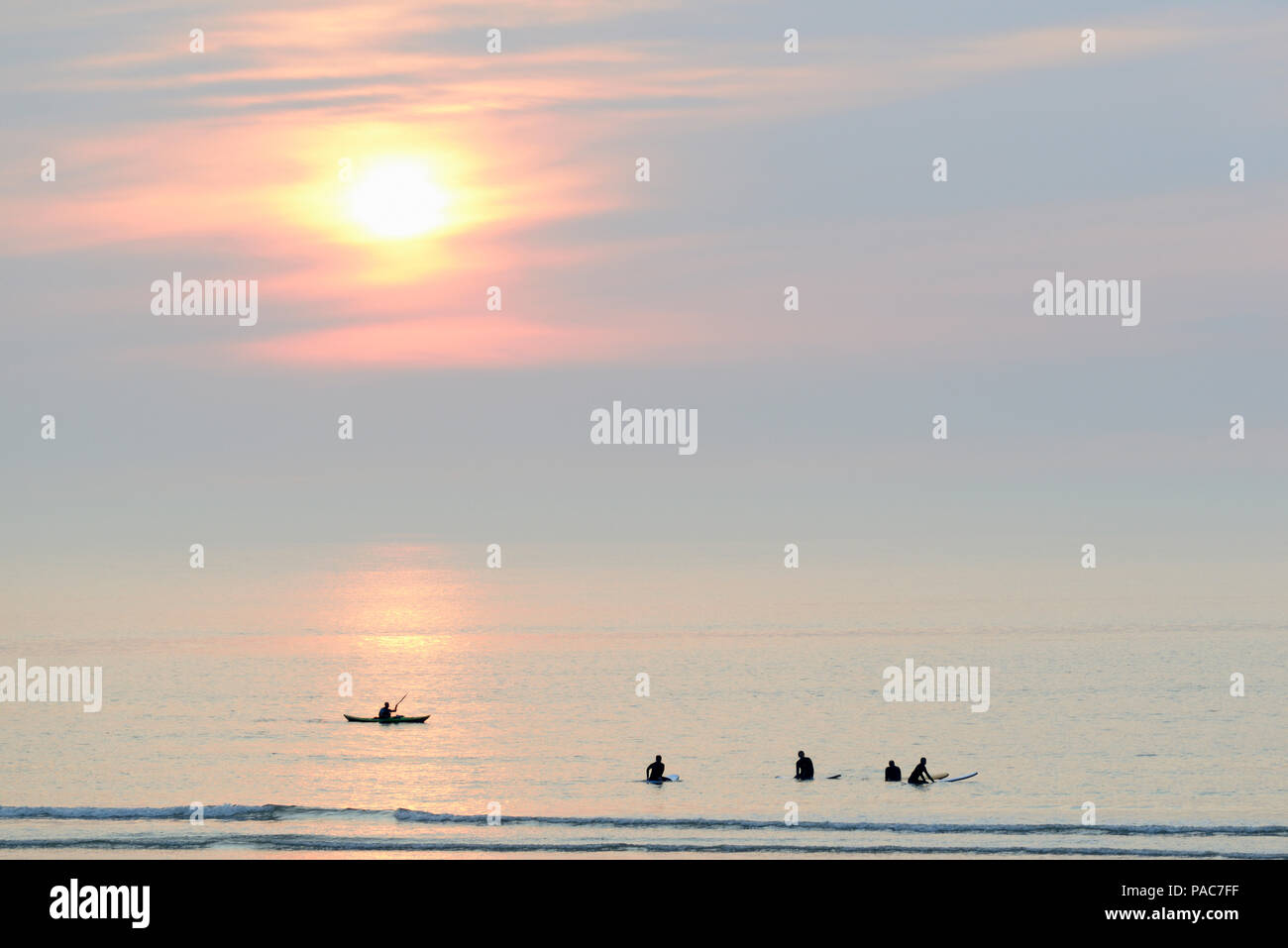 Des silhouettes, les surfeurs et kayakistes de mer calme sur la mer du Nord dans la soirée, Norderney, îles de la Frise orientale, Basse-Saxe Banque D'Images
