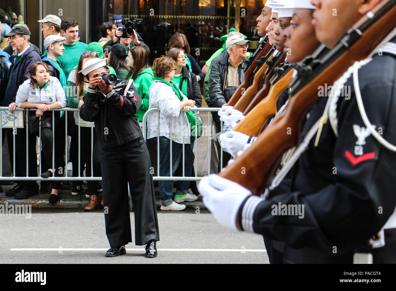 La Marine américaine spécialiste de la communication de masse 2e classe joue le destin de la Marine américaine Garde de cérémonie photos membres de sa commande, au cours de la Cinquième Avenue du 255e défilé de la Saint-Patrick à New York City. (U.S. Photo de la marine par le Lieutenant Matthew Stroup/libérés) Banque D'Images