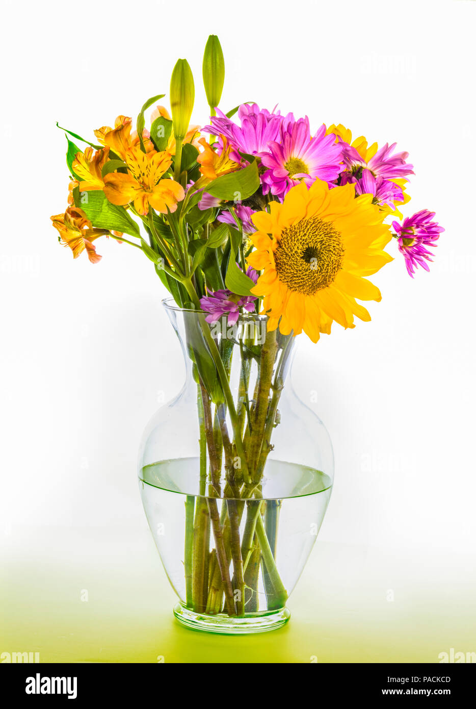 Bouquet attrayant arrangement des fleurs multicolores en vase en verre clair Banque D'Images