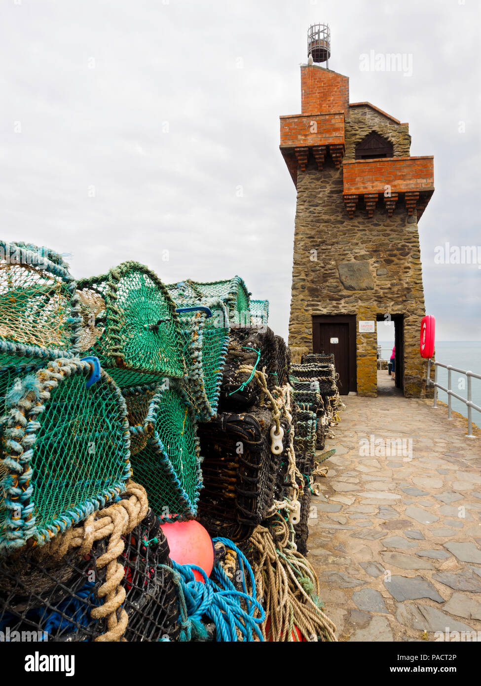 Des casiers à homard en face de la tour rhénane sur le mur de Lynmouth Harbour, Devon, Angleterre, Royaume-Uni Banque D'Images Des casiers à homard en face de la tour rhénane sur le mur de Lynmouth Harbour, Devon, Angleterre, Royaume-Uni Banque D'Images
