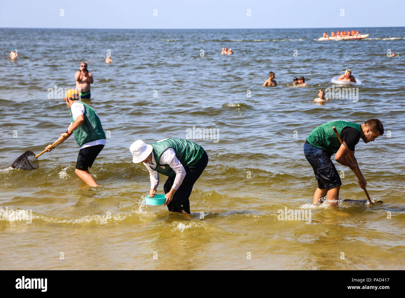 Jantar, Pologne. 21 juillet, 2018. Les gens participent à la chasse au Championnat du monde d'Ambre Jantar, dans le nord de la Pologne, le 21 juillet 2018. Des centaines de personnes ont participé au Championnat du Monde de chasse orange en finale du Jantar le samedi. Championnat du Monde de la chasse d'Ambre, qui a eu lieu depuis 1998, consiste à prendre et choisir autant d'ambres que possible à l'heure, dans un poste désigné. Les chasseurs peuvent utiliser l'épuisette et d'autres outils. Crédit : Chen Xu/Xinhua/Alamy Live News Banque D'Images