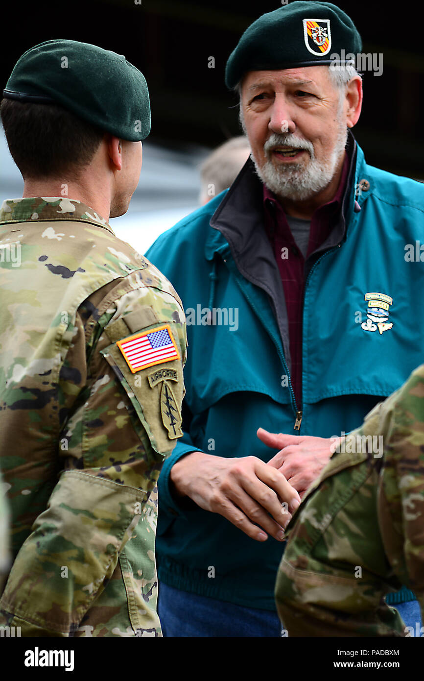 A l'époque du Vietnam 5 Special Forces Group (Airborne) Soldats parle à un des membres actuels du 5e SFG(A) après la conclusion de la cérémonie de passage de flash à Fort Campbell, Kentucky, le 23 mars 2016. Au cours de la cérémonie, 5e SFG(A) a rétabli l'époque Vietnam beret, l'ajout d'un flash une bande jaune en diagonale avec trois bandes rouges à l'arrière-plan noir et blanc. Les rayures rendent hommage à l'histoire du groupe dans la guerre du Vietnam et son creuset sous le feu. Banque D'Images