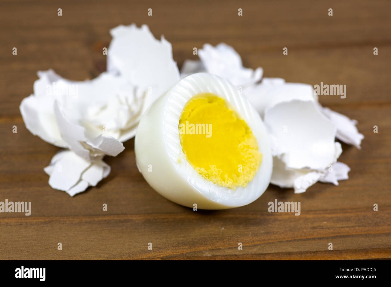 La moitié d'un oeuf dur avec les coquilles portant sur la table de cuisine Banque D'Images