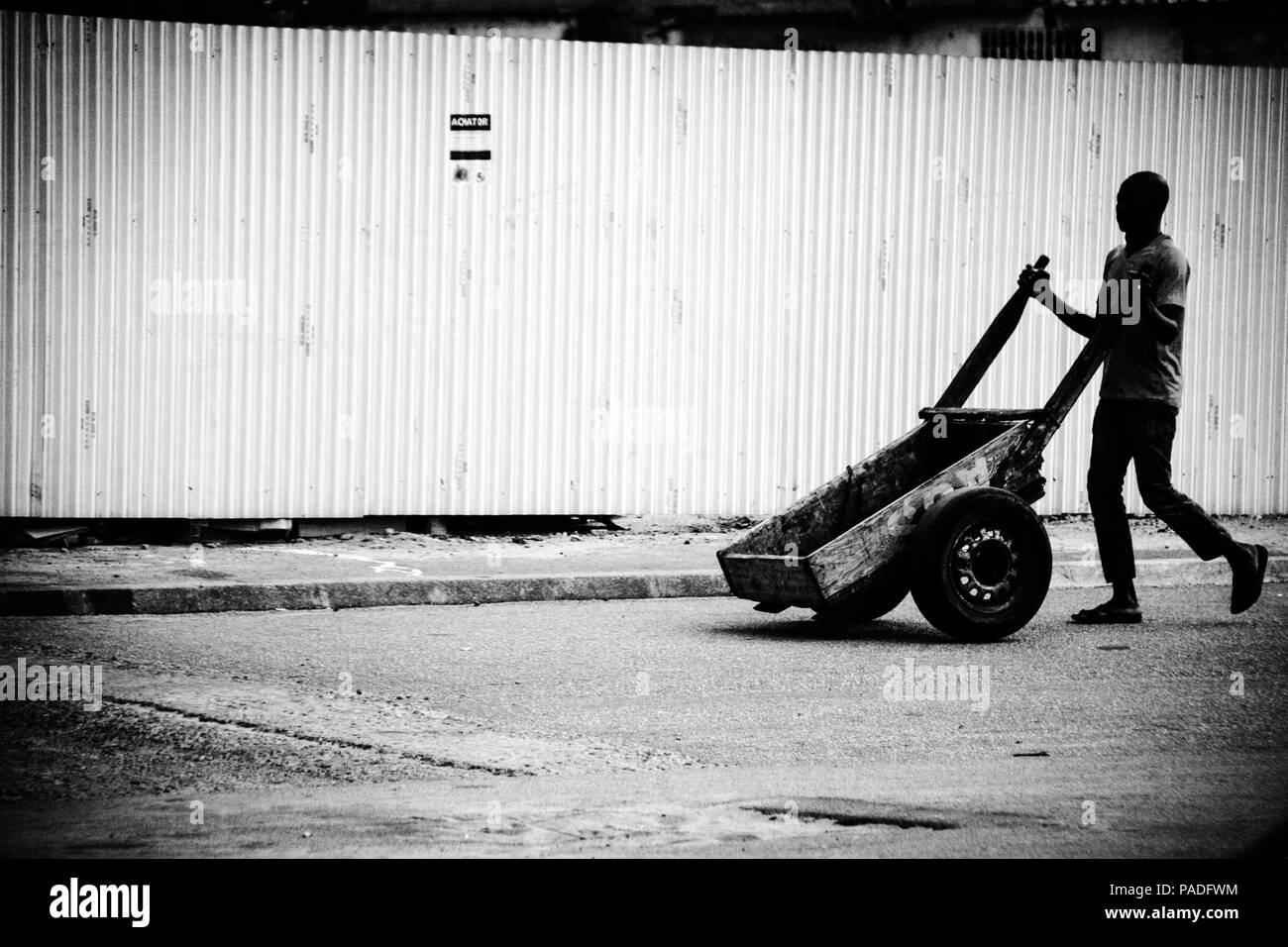 Homme africain poussant sa charrette vers le marché à Abidjan, Côte d'Ivoire Banque D'Images